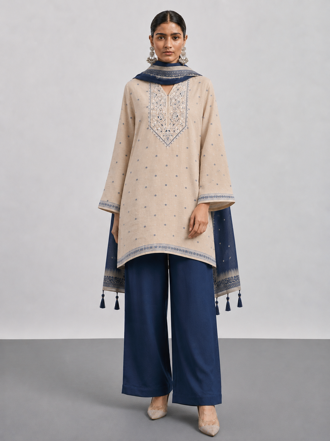 Shop this beige Chanderi embroidered suit set featuring intricate thread work, a coordinating blue bottom and botanical Chanderi dupatta. An elegant choice for festive and occasion wear.
