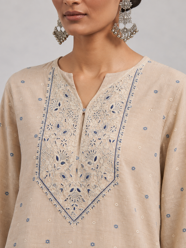 Shop this beige Chanderi embroidered suit set featuring intricate thread work, a coordinating blue bottom and botanical Chanderi dupatta. An elegant choice for festive and occasion wear.