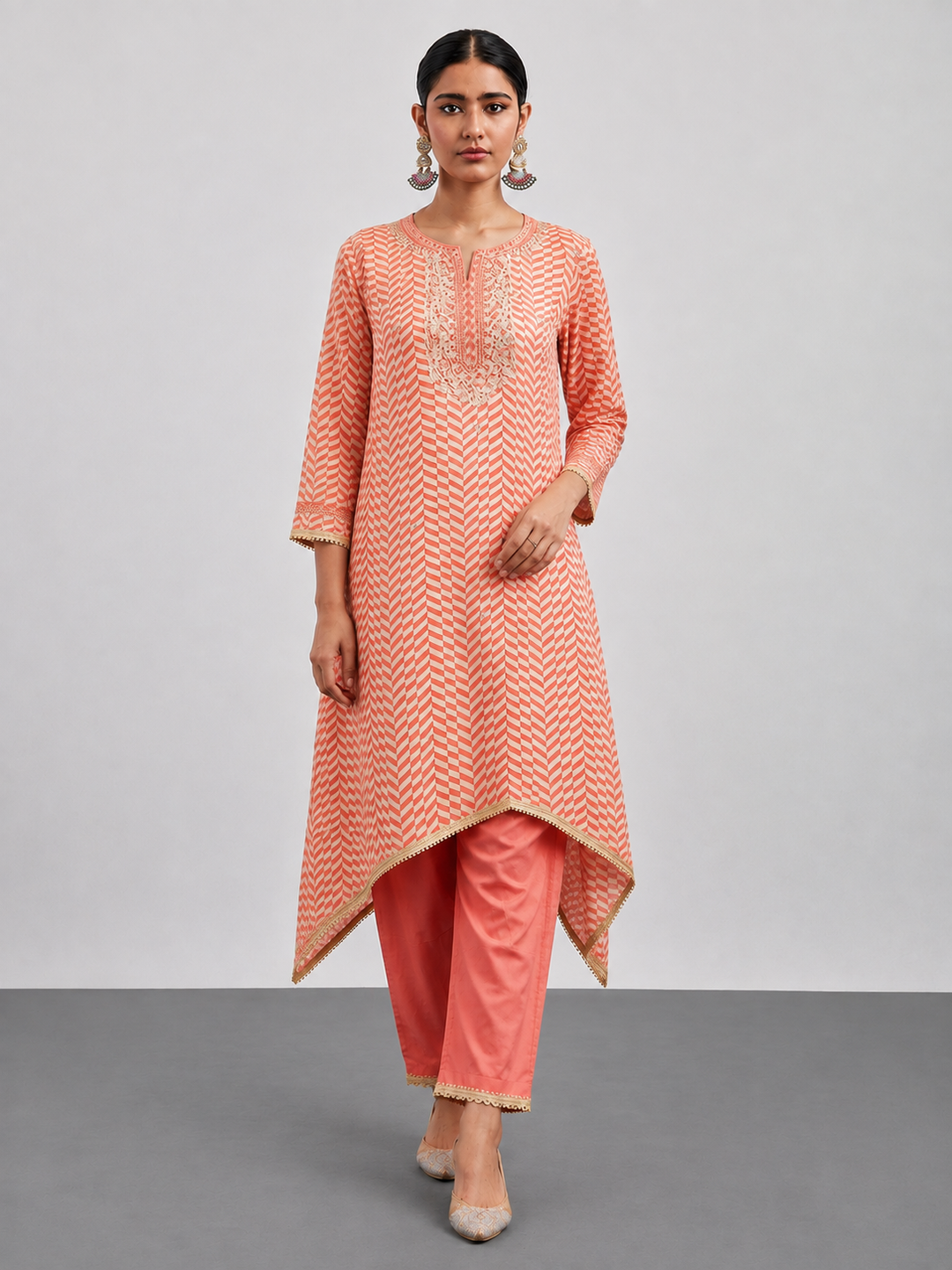 Shop the Coral Orange Organza Shimmer Set featuring a geometric chevron pattern and elegant zari detailing. A lightweight Indo-Western style for festive and special occasions.