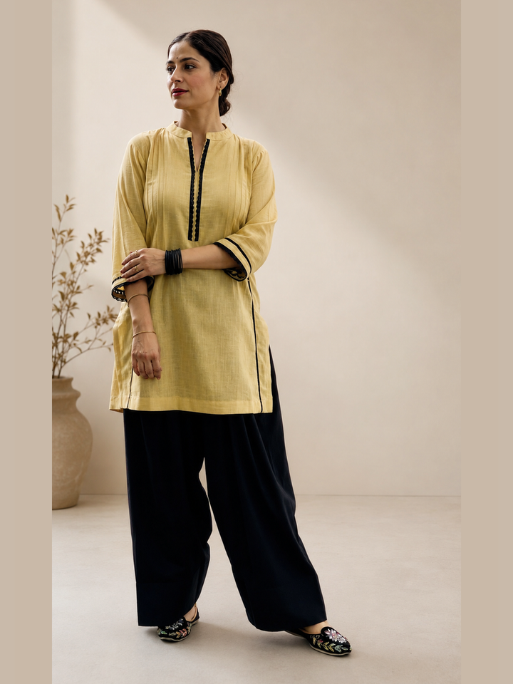 Beige women’s kurta with black detailing and black farshi salwar by Lush Layers