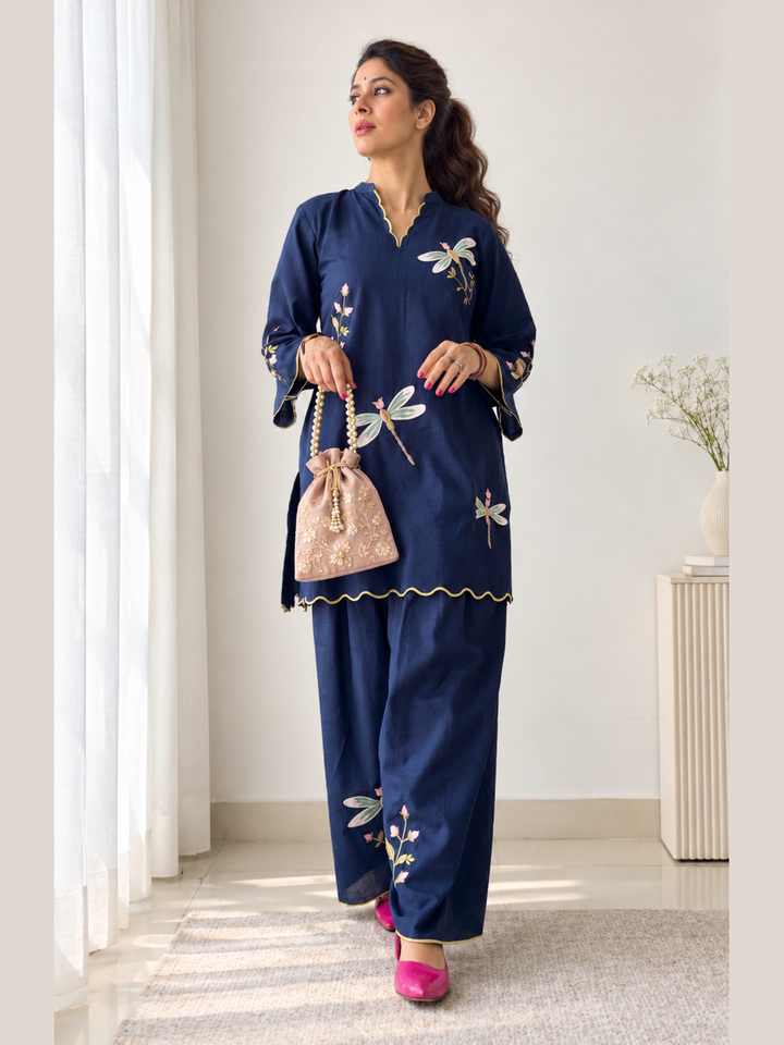  Lush Layers navy dragonfly embroidered co-ord set, crafted from a premium soft cotton–lyocell blend for effortless everyday elegance. Navy dragonfly embroidered cotton–lyocell co-ord set with matching trousers by Lush Layers. Softness, with a little detail.
Navy Dragonfly Co-ord Set
