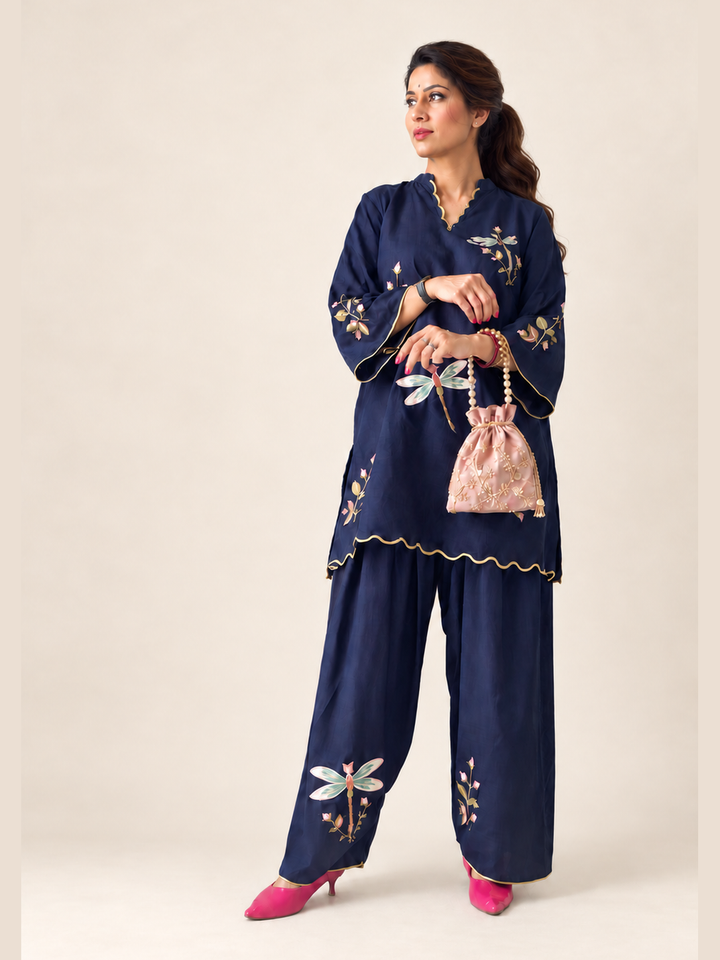  Lush Layers navy dragonfly embroidered co-ord set, crafted from a premium soft cotton–lyocell blend for effortless everyday elegance. Navy dragonfly embroidered cotton–lyocell co-ord set with matching trousers by Lush Layers. Softness, with a little detail.
Navy Dragonfly Co-ord Set