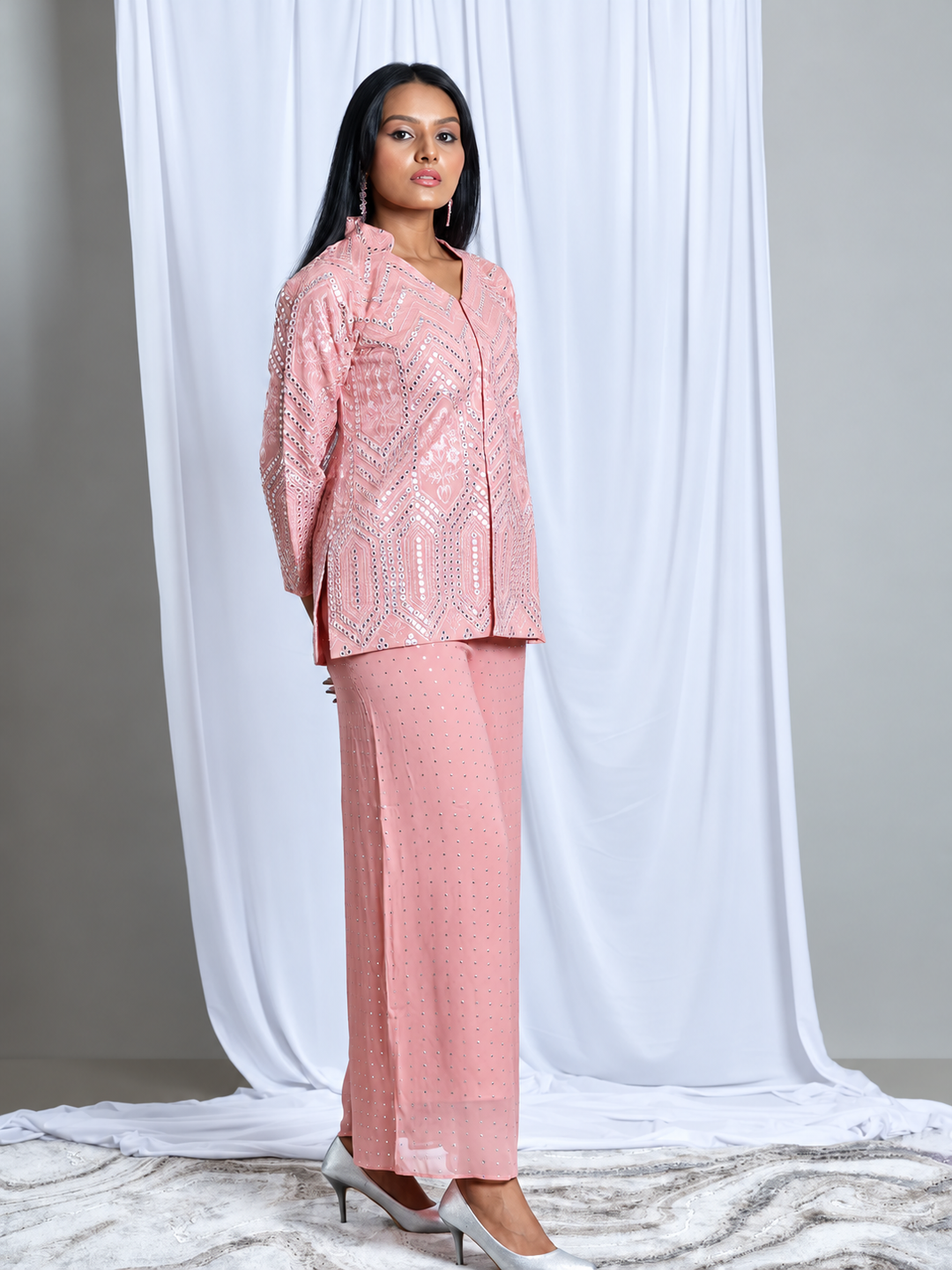 Shop the Baby Pink Embroidered Set by Lush Layers, featuring a detailed jacket-style top and matching wide-leg trousers for festive and evening occasions. Model wearing a baby pink embroidered jacket-style top with matching embellished wide-leg trousers.