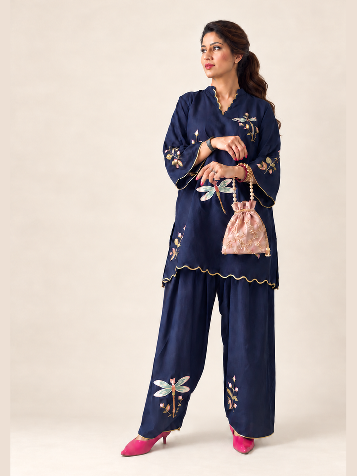  Lush Layers navy dragonfly embroidered co-ord set, crafted from a premium soft cotton–lyocell blend for effortless everyday elegance. Navy dragonfly embroidered cotton–lyocell co-ord set with matching trousers by Lush Layers. Softness, with a little detail.
Navy Dragonfly Co-ord Set