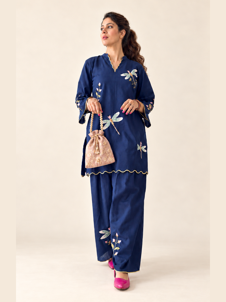  Lush Layers navy dragonfly embroidered co-ord set, crafted from a premium soft cotton–lyocell blend for effortless everyday elegance. Navy dragonfly embroidered cotton–lyocell co-ord set with matching trousers by Lush Layers. Softness, with a little detail.
Navy Dragonfly Co-ord Set